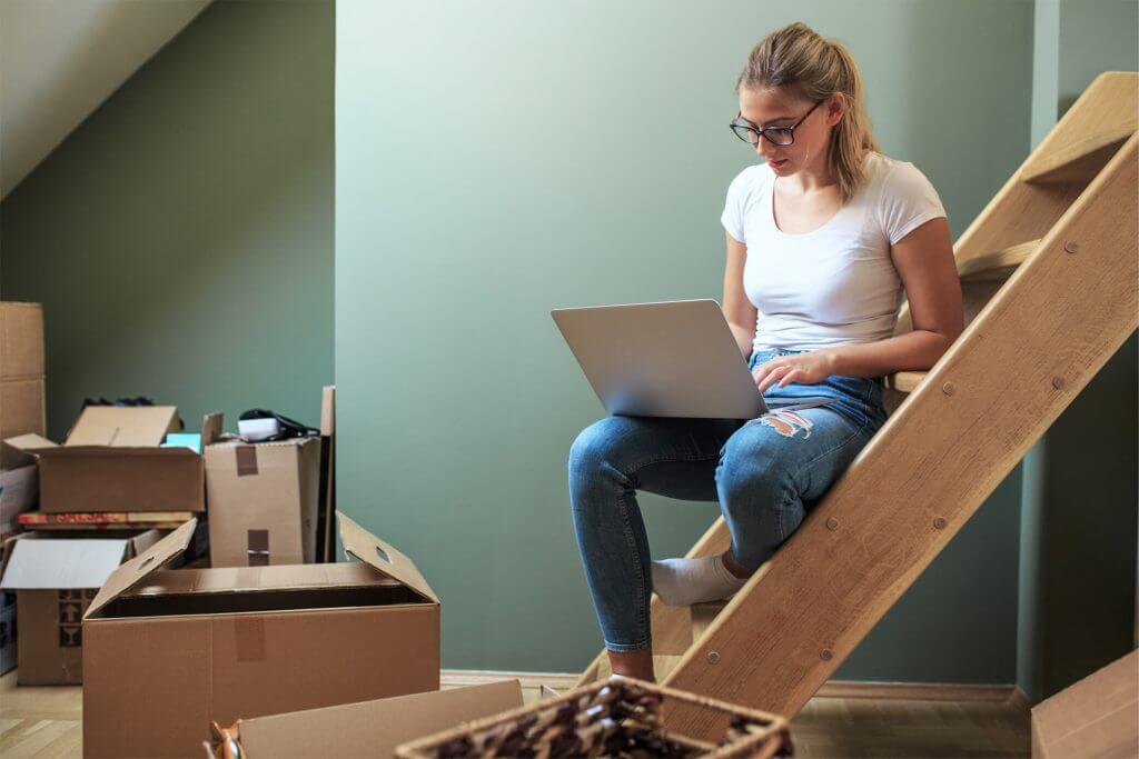 Woman working on laptop surrounded by boxes